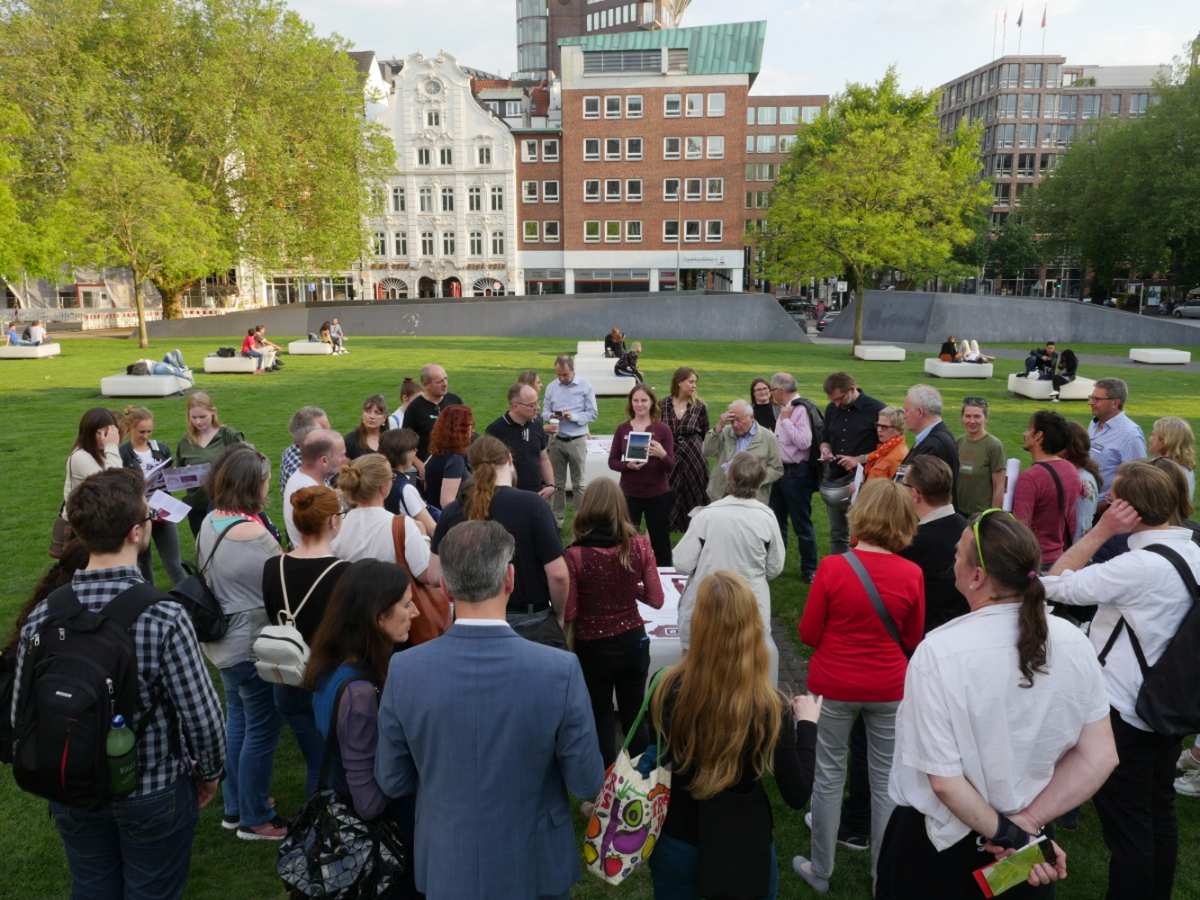 a group of people standing in a circle in a park