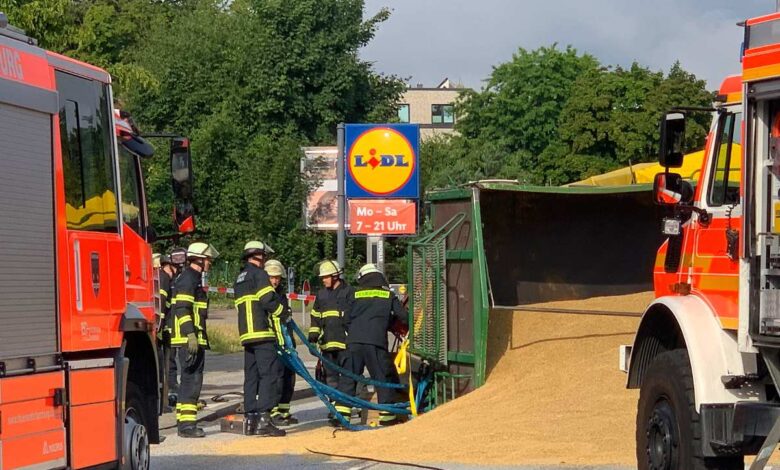 a group of firemen in uniform with a hose attached to a truck