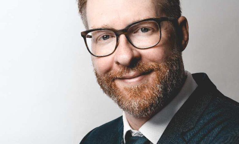 a man wearing glasses and a suit