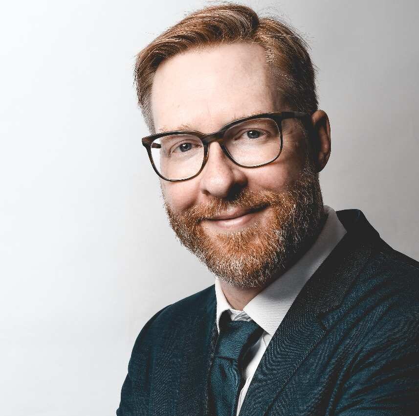 a man wearing glasses and a suit