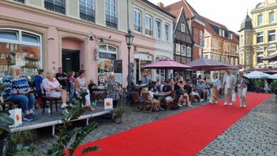a group of people sitting outside on a red carpet