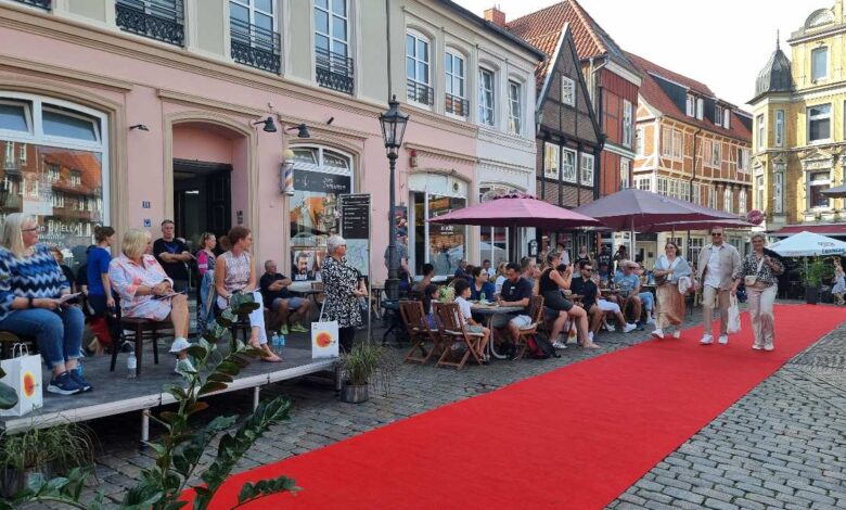 a group of people sitting outside on a red carpet