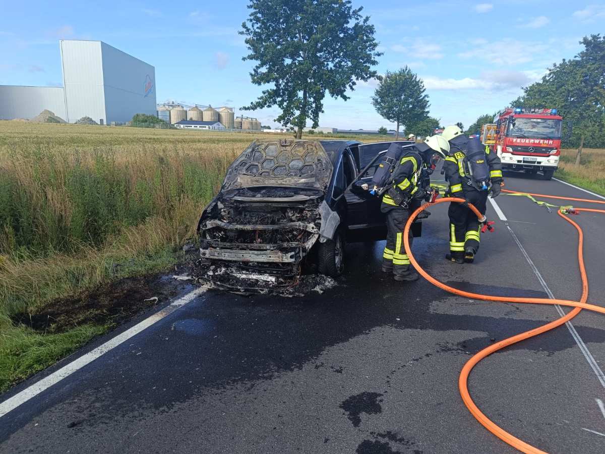 Ford fängt während der Fahrt Feuer – Familie rettet sich rechtzeitig 1 firefighters putting out a burnt out car on a road