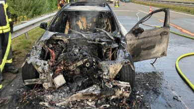 a burned out car on a road