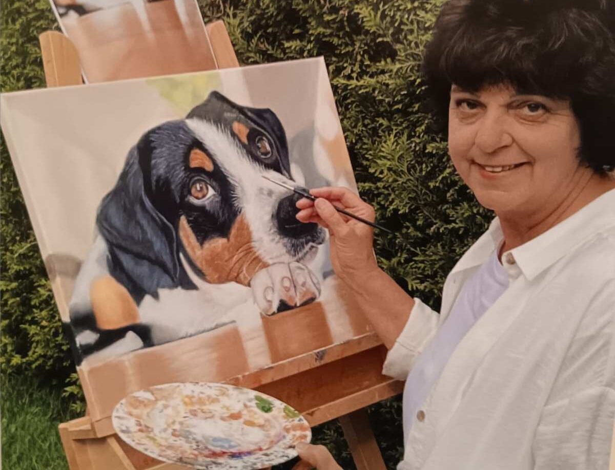a woman painting a dog