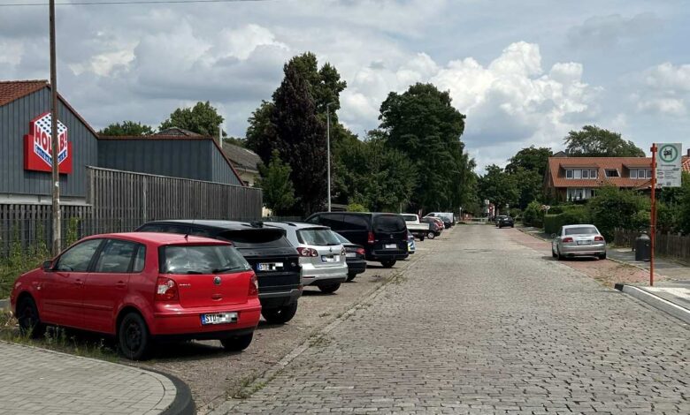 a row of cars parked on a brick road