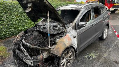 a burned out car with the hood open