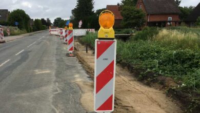 a road construction site with orange and white poles