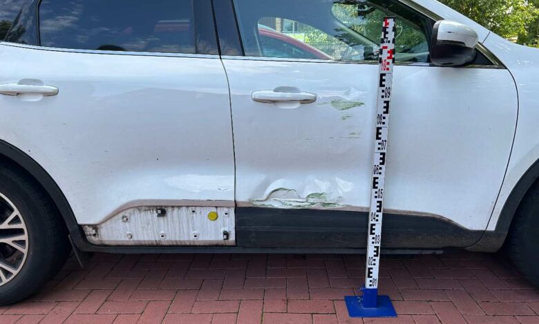 a white car with a white bumper and a white pole