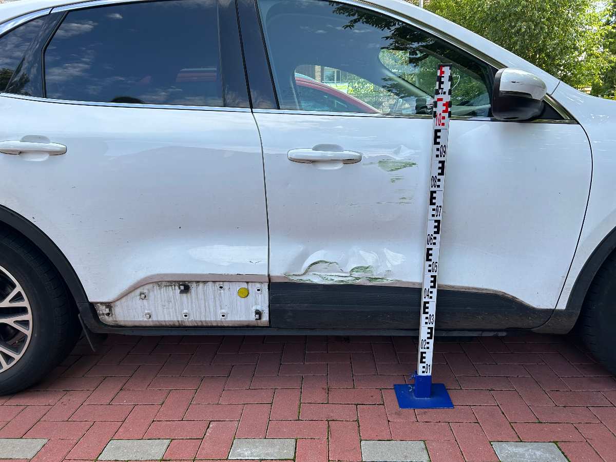 a white car with a white bumper and a white pole