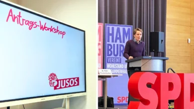a man standing at a podium with a screen in front of him