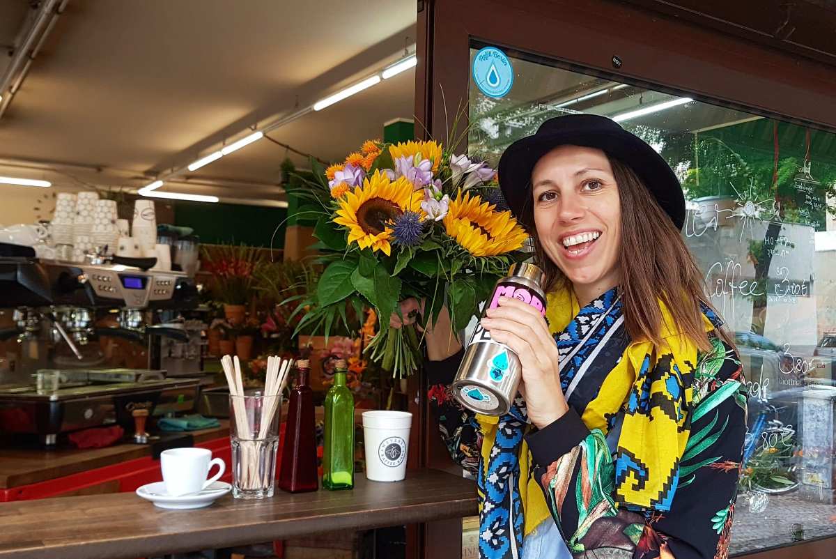 a woman holding a thermos and smiling