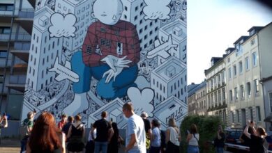 a group of people standing in front of a mural