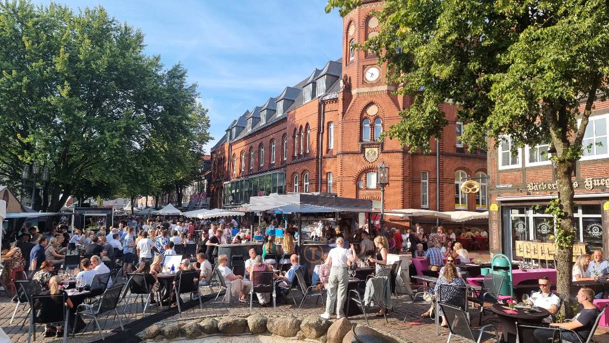 Stader Winzerfest lädt zum Genießen und Verweilen auf dem Pferdemarkt ein 1 a group of people sitting at tables outside a building