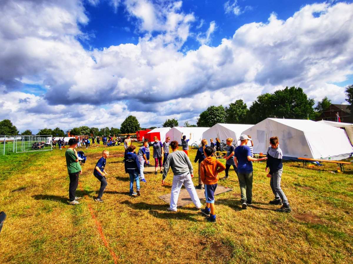 a group of people standing in a field with tents