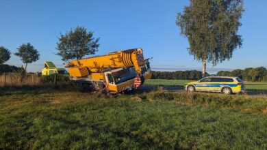 a yellow truck crashed into a car on the side of the road
