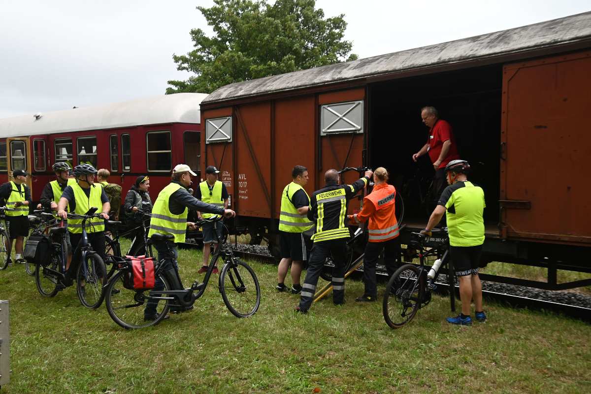 a group of people in yellow vests standing next to a train