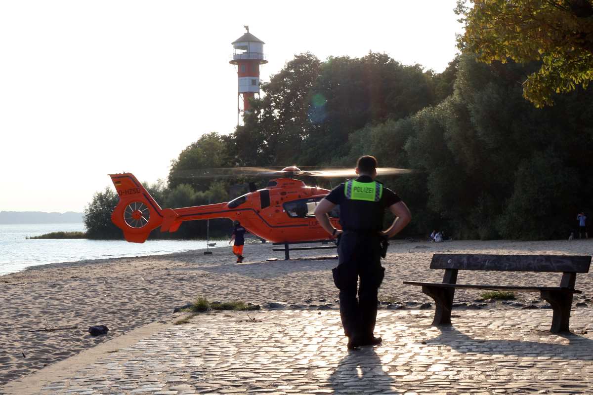 a man standing on a brick path near a helicopter