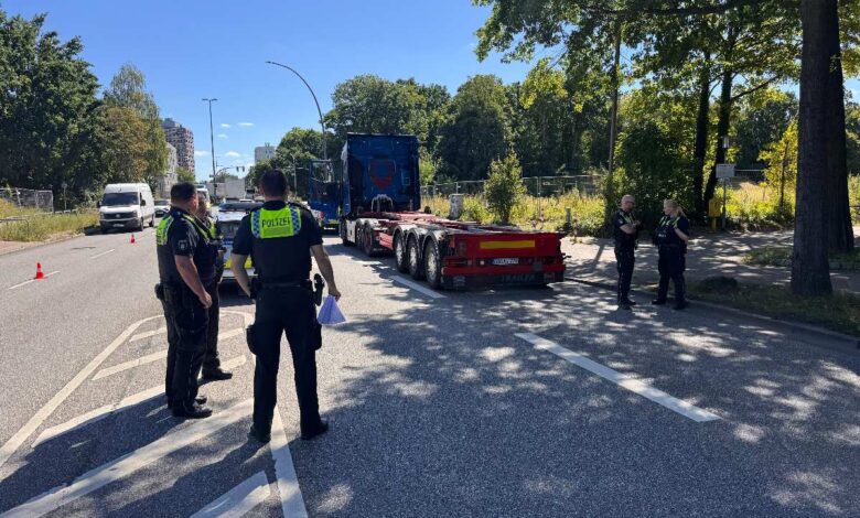 a group of police officers standing in front of a semi truck