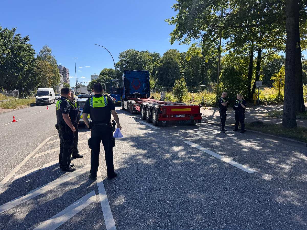 a group of police officers standing in front of a semi truck