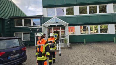 a group of firefighters walking outside a building