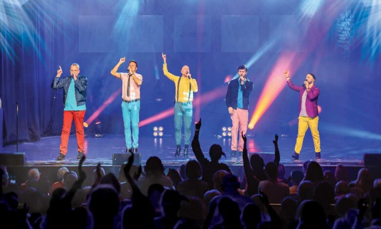 a group of men on stage with microphones and a crowd of people