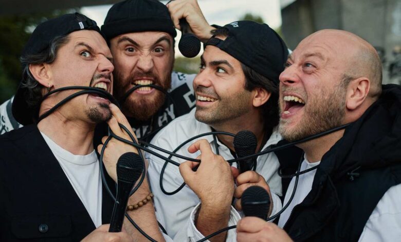 Vier Männer mit Mikrofonen zusammen.