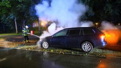 a fireman spraying water on a car