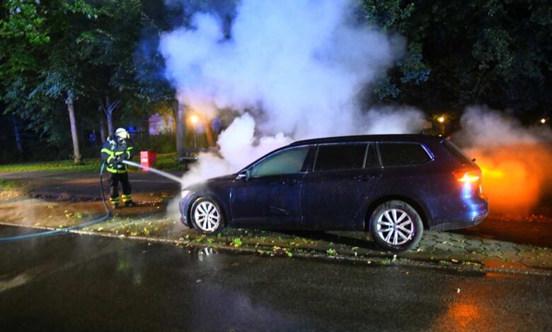 a fireman spraying water on a car