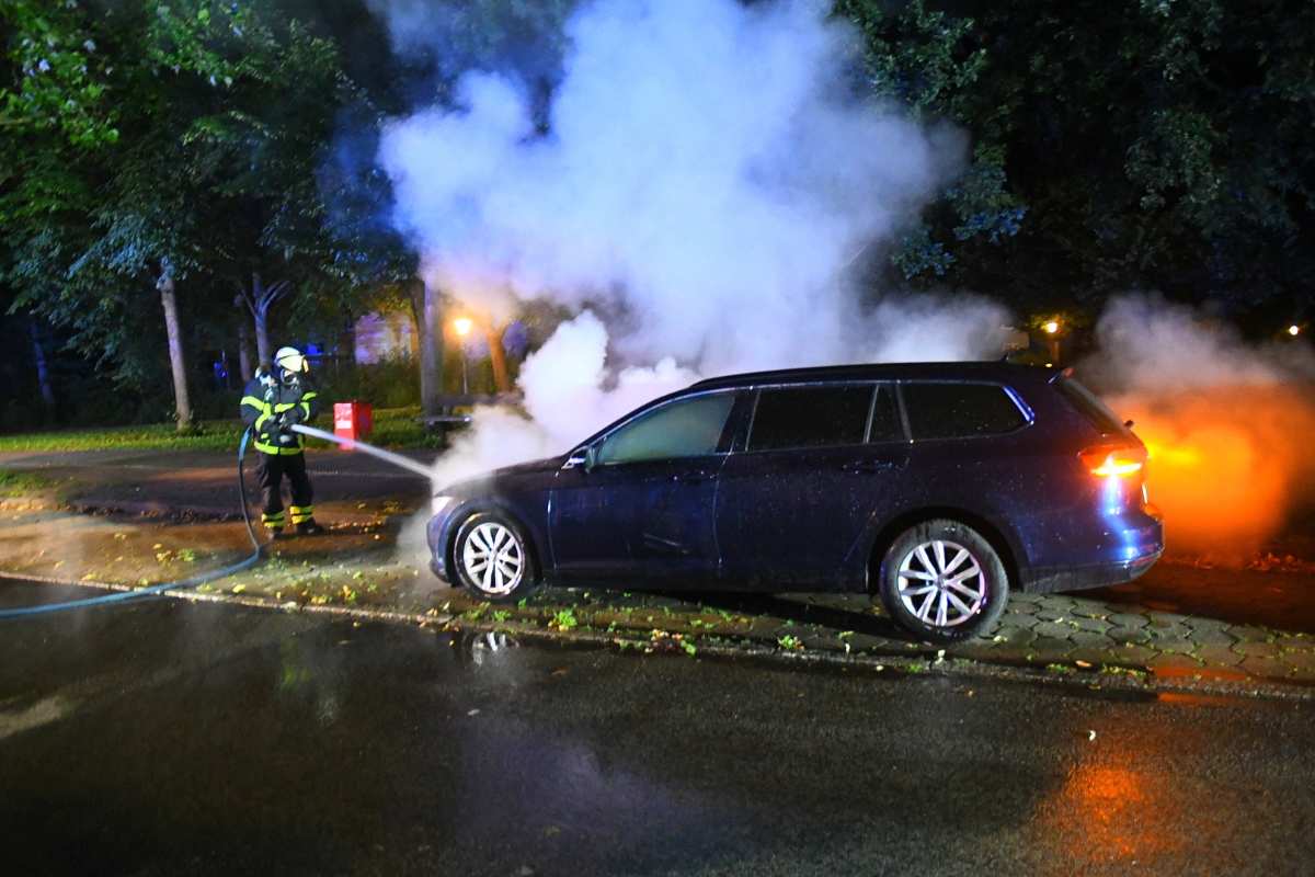 a fireman spraying water on a car