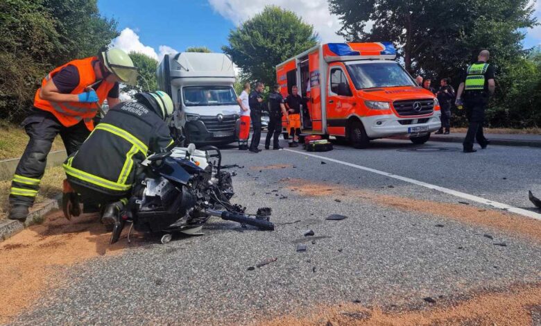 a group of people around a motorcycle on the road