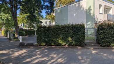 a building with a fence and bushes