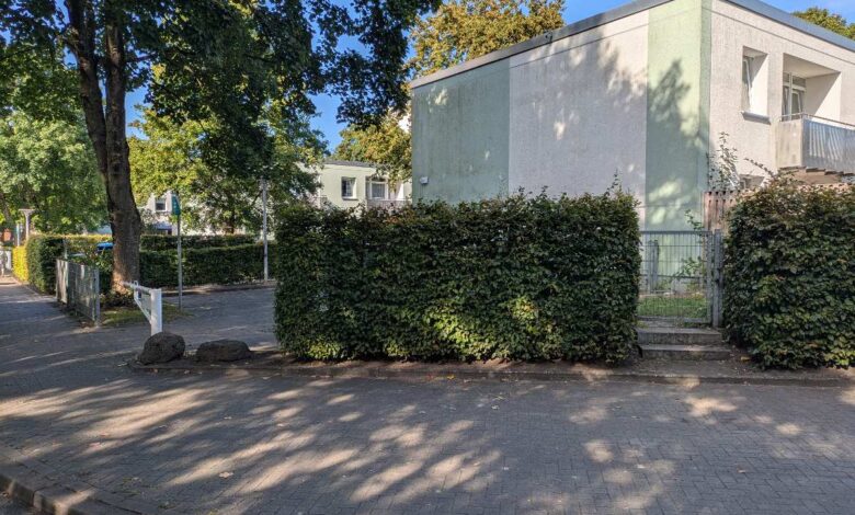a building with a fence and bushes