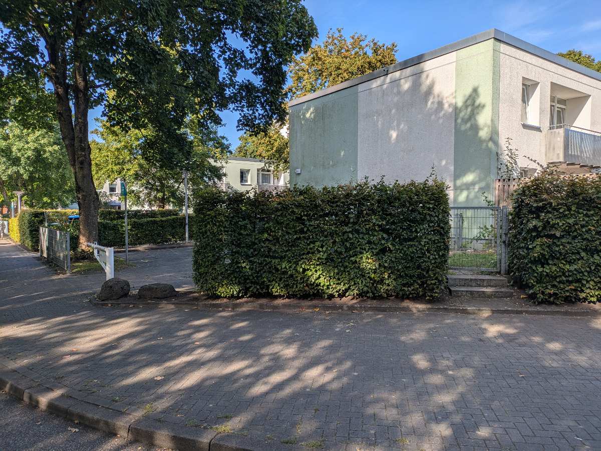 a building with a fence and bushes