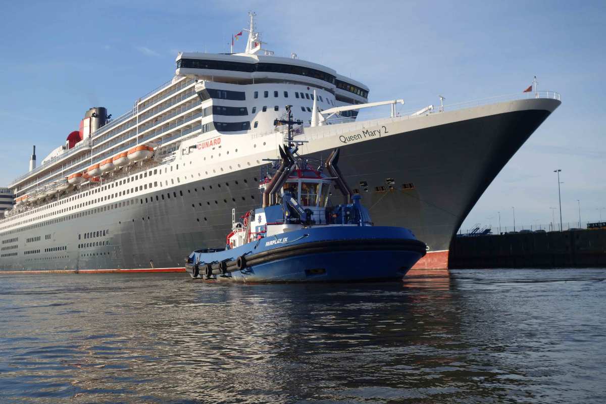 a boat in the water next to a large cruise ship