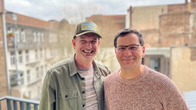 two men standing on a balcony