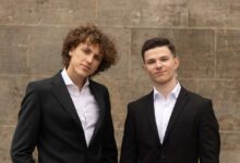 two men in suits standing next to each other
