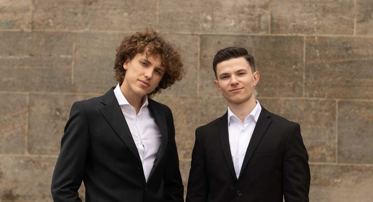 two men in suits standing next to each other