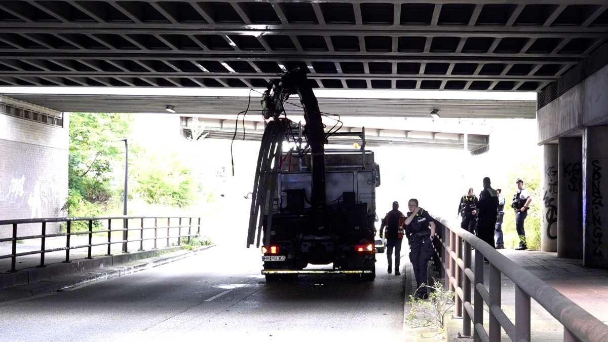 Lkw unter Brücke mit Polizei