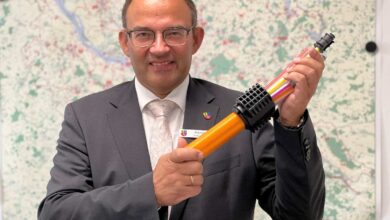 Mann hält ein farbiges Gerät.
