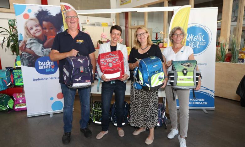 Vier Personen mit Schulranzen.