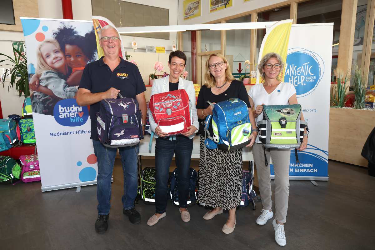 Vier Personen mit Schulranzen.
