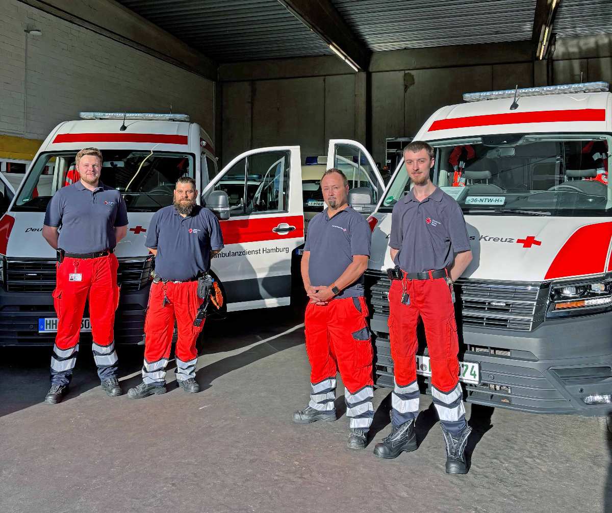 Rettungsdienstmitarbeiter vor Einsatzfahrzeugen.