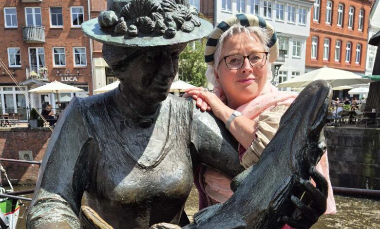 Statue mit Fisch und Besucherinnen.