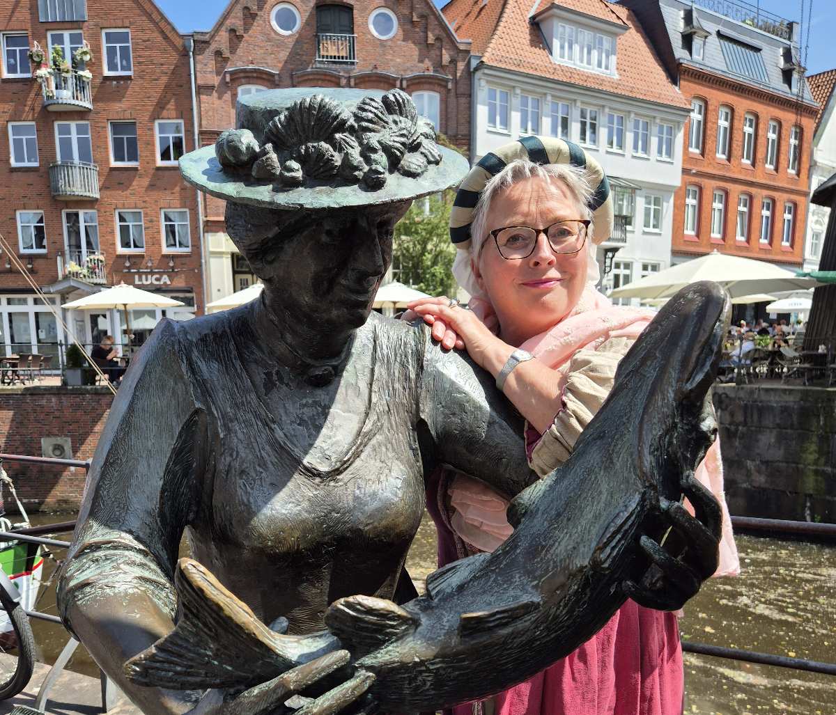 Statue mit Fisch und Besucherinnen.