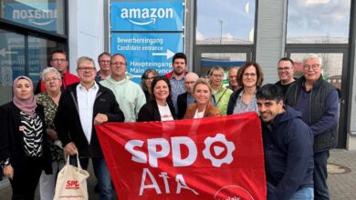 Gruppe mit SPD-Flagge vor Amazon