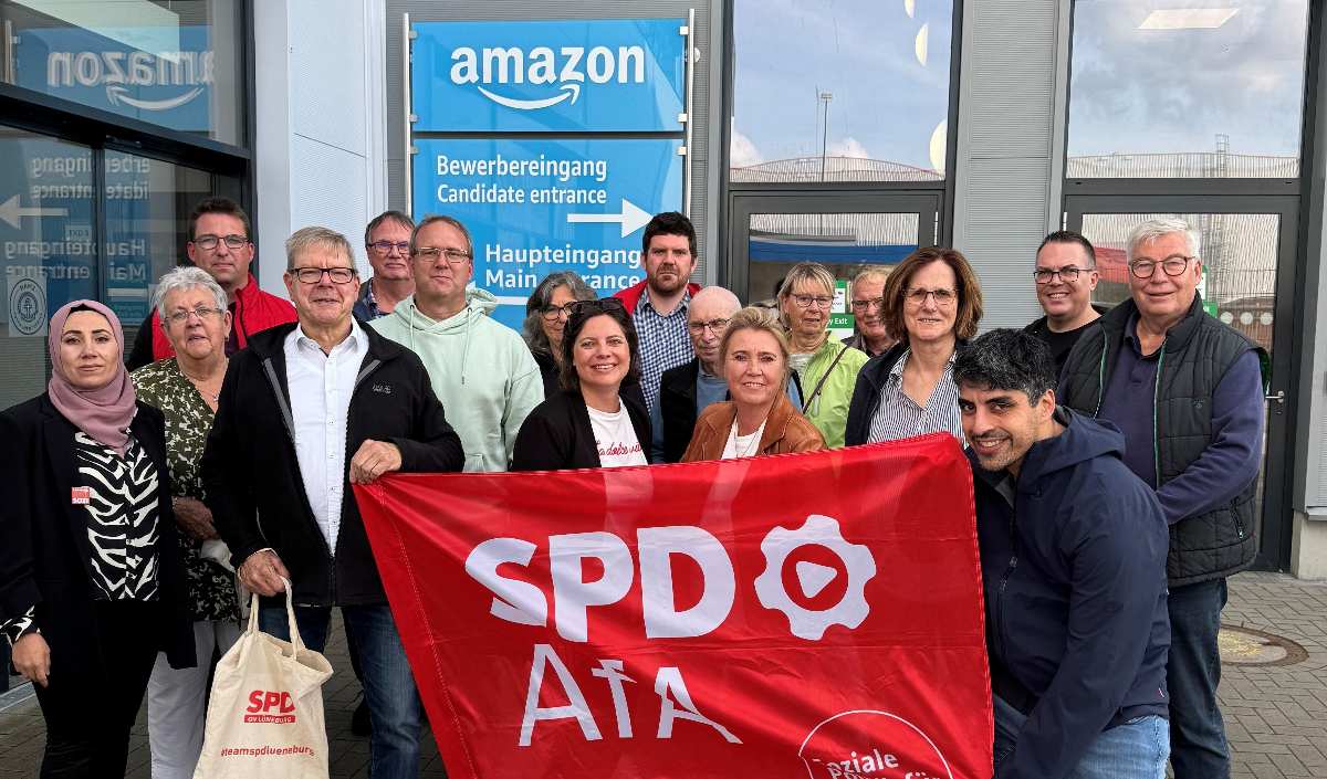 Gruppe mit SPD-Flagge vor Amazon
