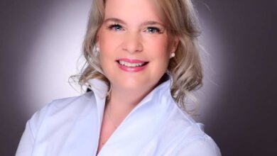 Frau in blauer Bluse mit verschränkten Armen.