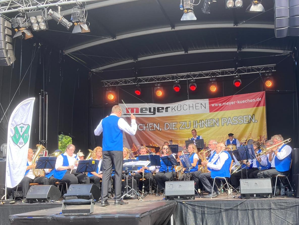 Blasorchester spielt auf der Bühne.