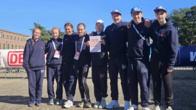Gruppe von Sportlern mit Urkunde